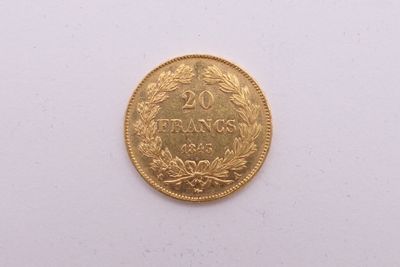 gros plan d'une pièce d'or sur une surface blanche
