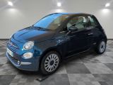 the small blue car is parked on a checkered tile floor
