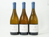 trois bouteilles de vin posées sur une table blanche