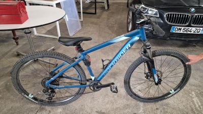 un vélo qui est garé dans un garage à côté d'une voiture