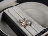 une paire de boucles d'oreilles dans un écrin posé sur une table