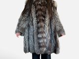 the woman is wearing a fur coat and black pants