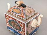 une image représentant une boîte décorative sur laquelle est posé un chat