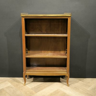 a wooden bookcase with three shelves on top of a herringle floor