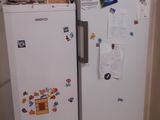 two refrigerators in a small kitchen with boxes on top of them