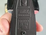 a person holding a black toy car in their hand