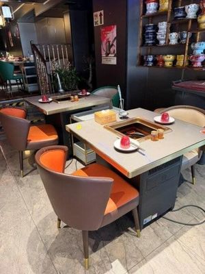 de nombreuses chaises et tables dans un restaurant, avec un pot-au-feu sur chaque table