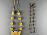 two pieces of jewelry are displayed on a gray surface