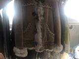 a person holding a coat on a rack in a room