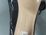 the bottom of a pair of black high heeled shoes on a table