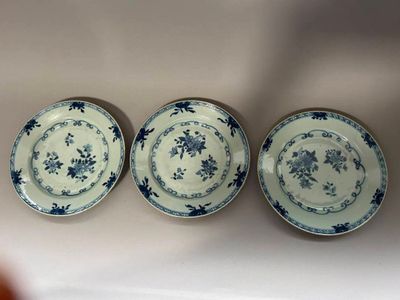 trois assiettes bleues et blanches posées sur un plan de travail blanc