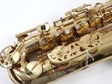 a gold saxophone that is sitting on a white surface