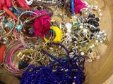 a wooden bowl filled with lots of jewelry on a table