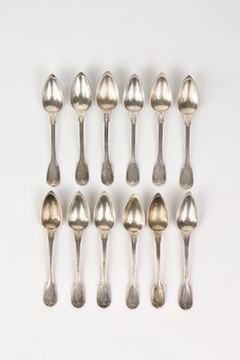 six cuillères en argent sont disposées en ligne sur une surface blanche