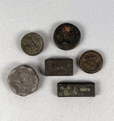 Plusieurs vieilles pièces de monnaie sont posées sur une surface blanche