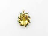 a yellow sapphire and emerald pendant on a white background