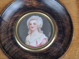 a miniature picture of a woman in a dress on a plate