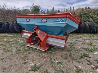un bateau bleu et rouge posé dans l'herbe