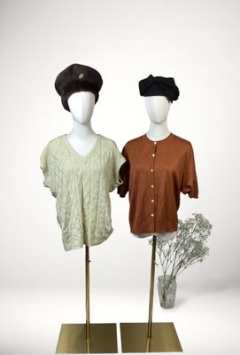 pair of mannequins with hats on display in front of a white background