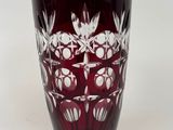 a red glass vase with white flowers on it