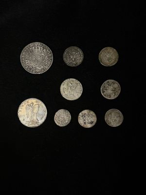 un gros plan sur un tas de pièces d'argent posées sur une surface noire