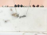 un coffret en marbre blanc sur lequel sont posés un collier et une bague