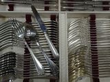 many forks and spoons in a wooden box