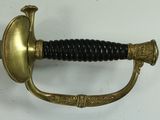 a gold sword with a black handle on a white surface