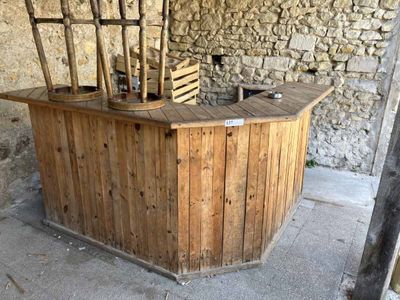 a wooden table with four chairs on it in front of a stone wall