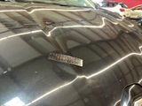 a sticker on the hood of a car that is parked in a lot