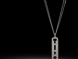 a black and white photo of a dog tag necklace on a chain