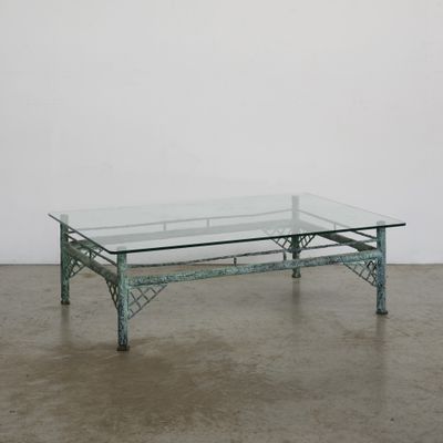 une photo d'une table basse en verre posée sur un sol en béton