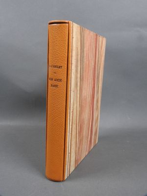 an orange book sitting on top of a table next to a gray background