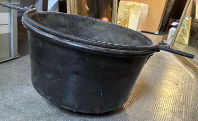 un grand pot noir posé sur une table dans une pièce