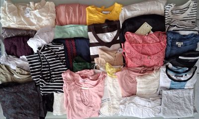 une valise remplie de vêtements, tous entassés les uns sur les autres