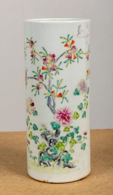 un vase blanc orné d'un oiseau et de fleurs