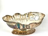 a silver bowl that is on a stand on a white surface
