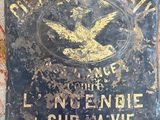 an old sign on the wall of a building with a bird on it