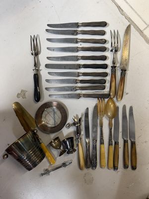 de nombreux types de couteaux et de fourchettes disposés sur une table