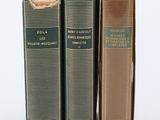 three books sitting on top of each other on a white surface