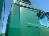 a green semi truck parked on the side of the road