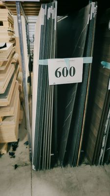 plusieurs piles de planches de bois empilées les unes sur les autres dans un entrepôt