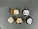 four different types of pocket watches sitting on top of a table