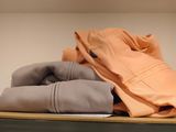 a shelf that has a bunch of clothes on top of it