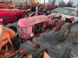 many old tractors in the garage of this building