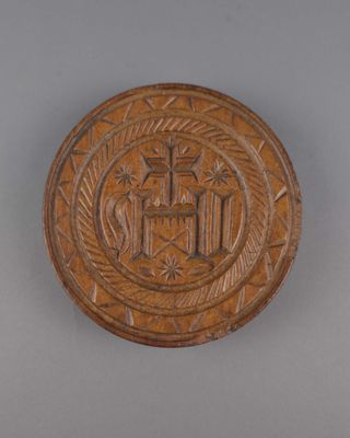 un gros plan d'une plaque en bois sur laquelle figure une croix