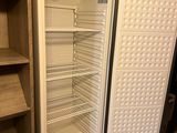 an empty refrigerator in the corner of a room