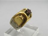 une image représentant une bague en or sertie d'un grenat