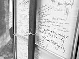 black and white photograph of a bulletin board with writing on it