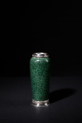 a green vase that is sitting on a black surface